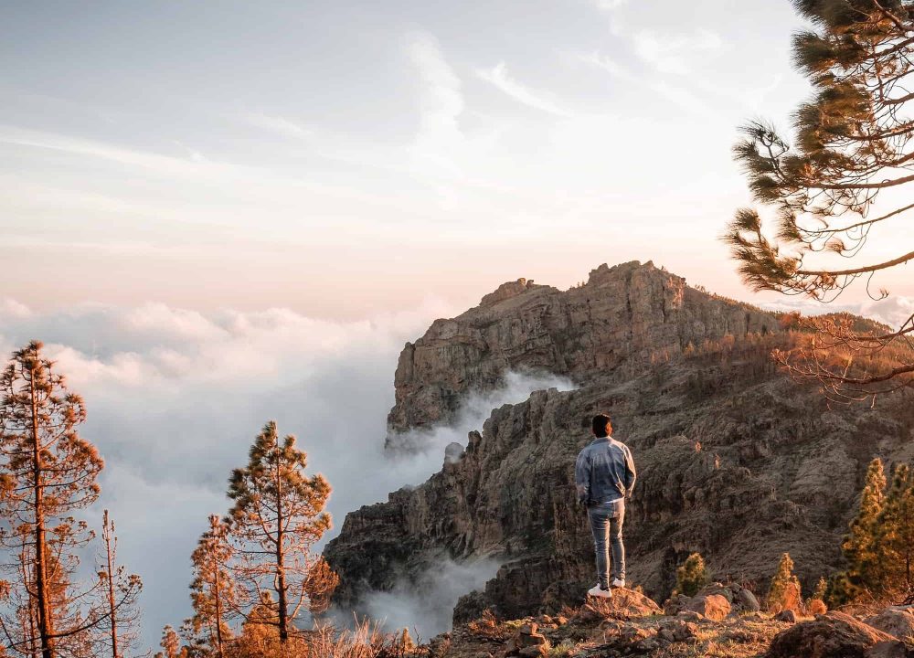 young-man-enjoying-sea-of-clouds-sunset-among-the-mountains.jpg